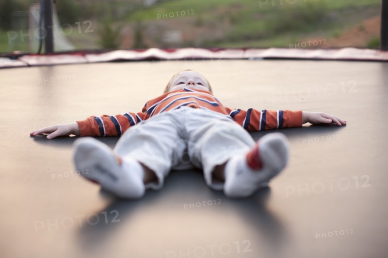 Caucasian boy laying on trampoline
