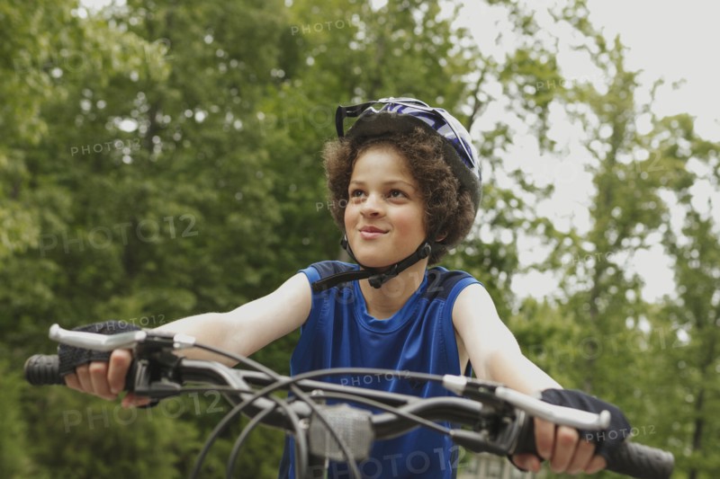 Mixed race boy riding bicycle outdoors