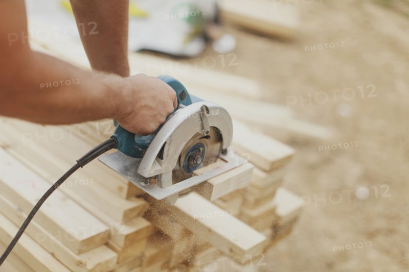Caucasian construction worker sawing wood planks