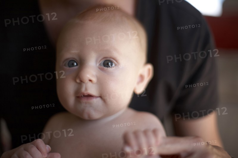 Caucasian mother holding baby's hands