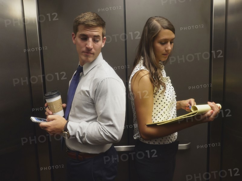 Business people ignoring each other in elevator