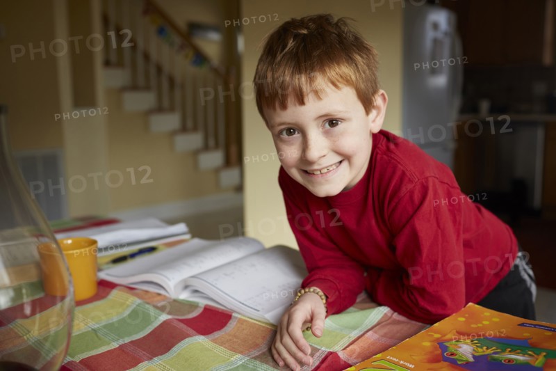 Caucasian boy doing homework at table