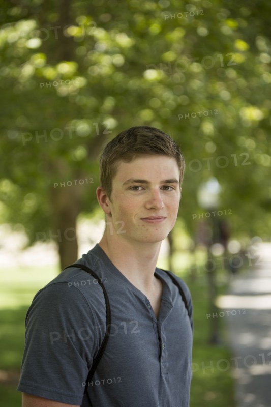 Caucasian student smiling on sidewalk