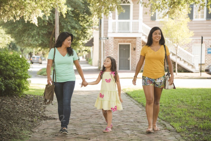 Hispanic mother and daughters walking in park