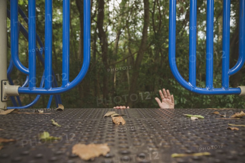 Hands of Hispanic girl reaching on playground