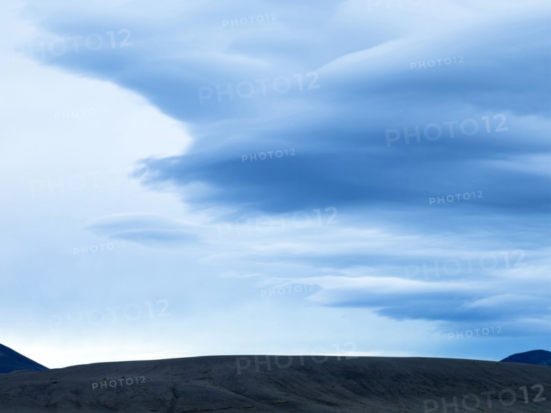 Silhouette of mountain range under cloudy sky