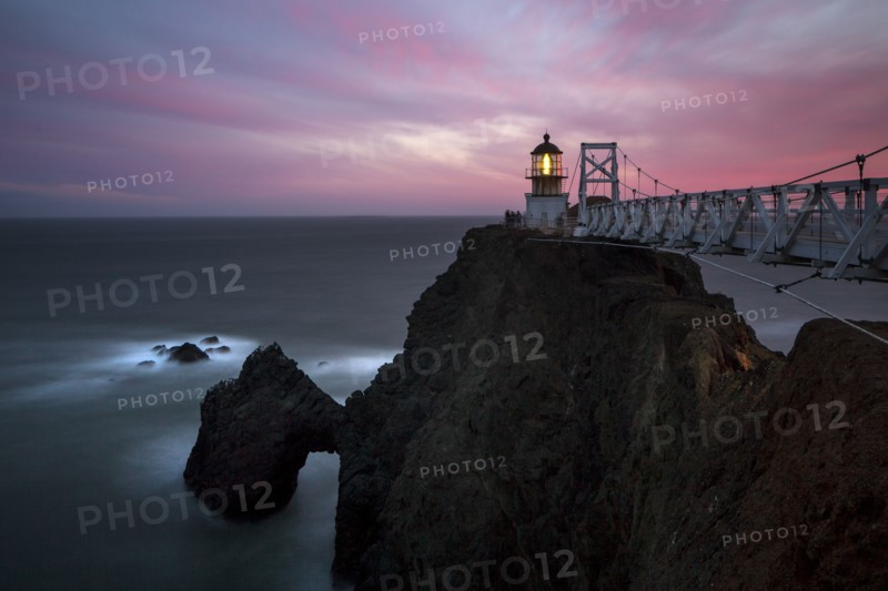 Lighthouse on rocky cliffs over ocean coastline