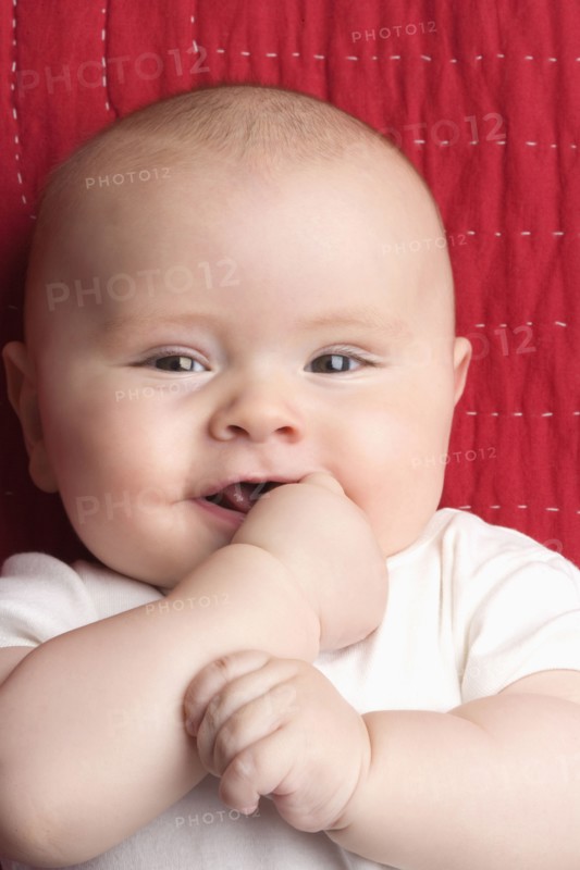 Caucasian baby biting hand