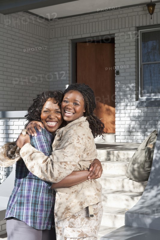 Black mother hugging soldier daughter