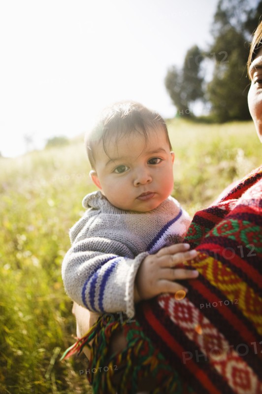 Mother holding baby in field
