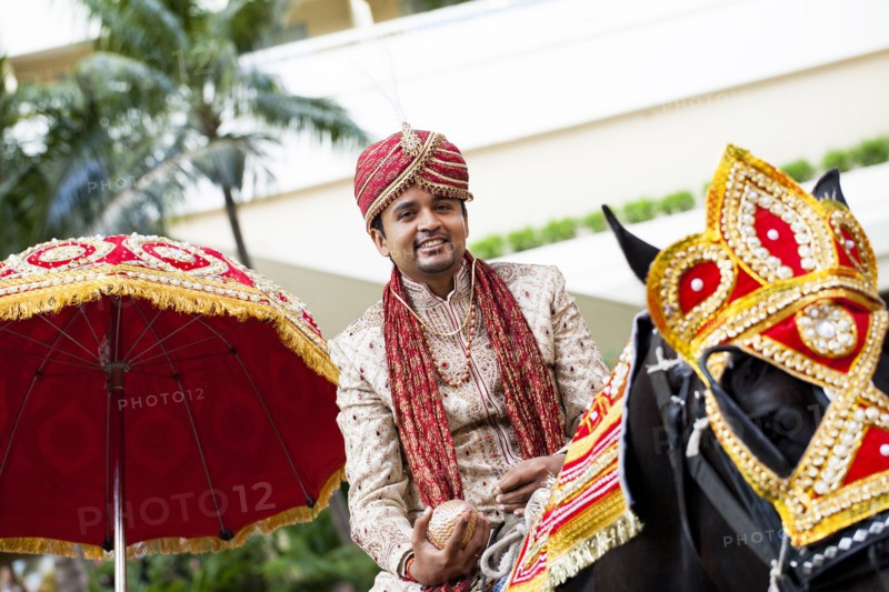 Indian groom riding horse in wedding procession