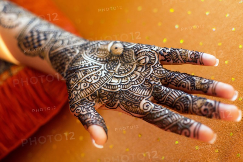 Close up of hand with intricate henna design