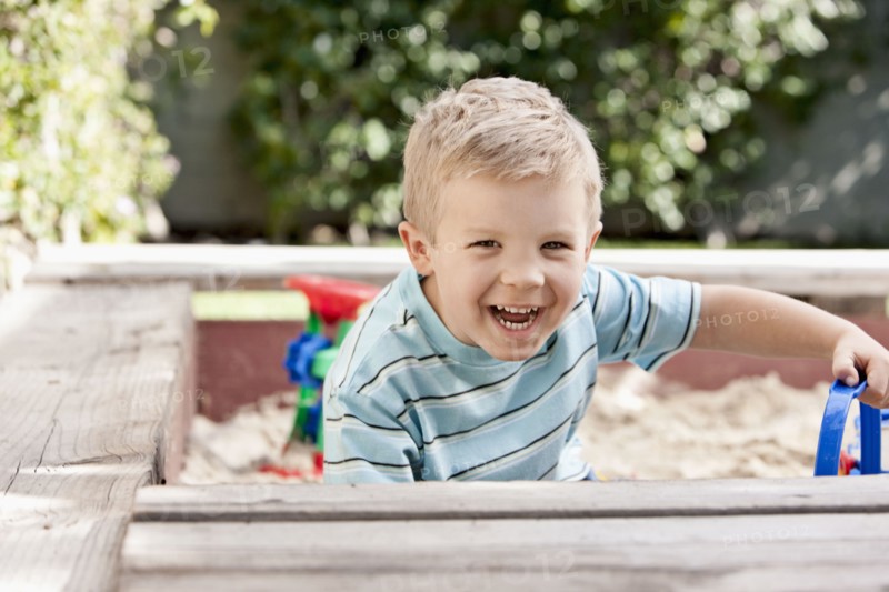 Caucasian boy playing in sandbox