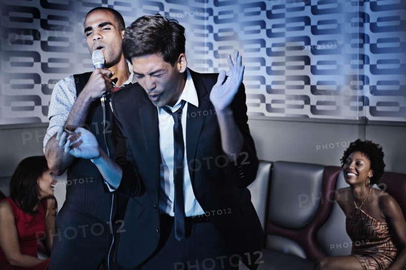 Friends singing karaoke in nightclub