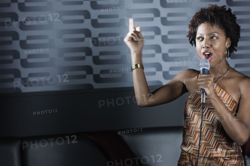 African American woman singing karaoke in nightclub