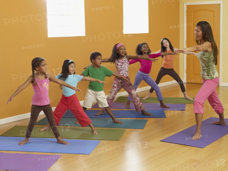 Teacher leading class of children in exercise routine