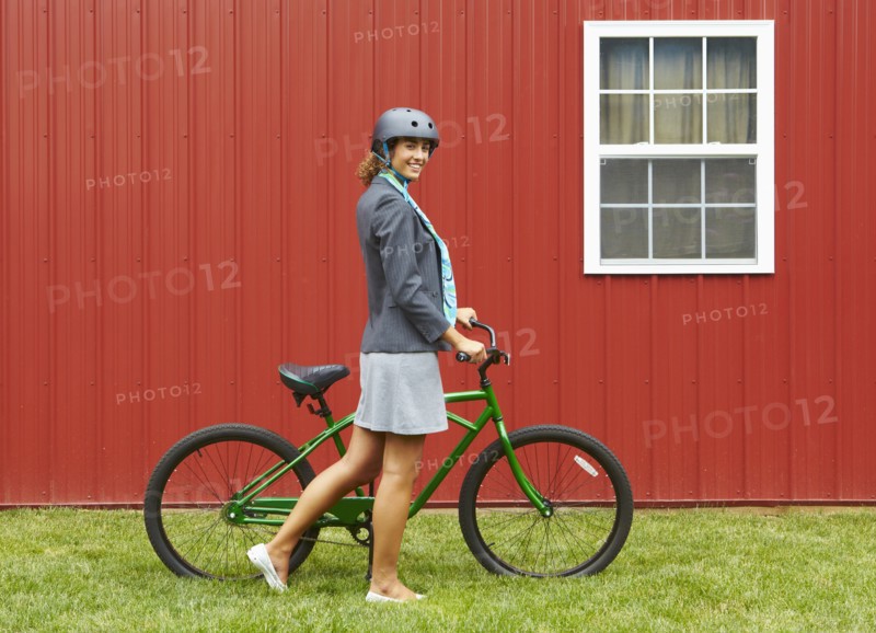 Mixed race woman in helmet standing with bicycle