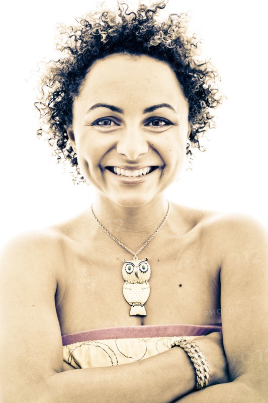 Close up portrait of smiling woman wearing owl necklace