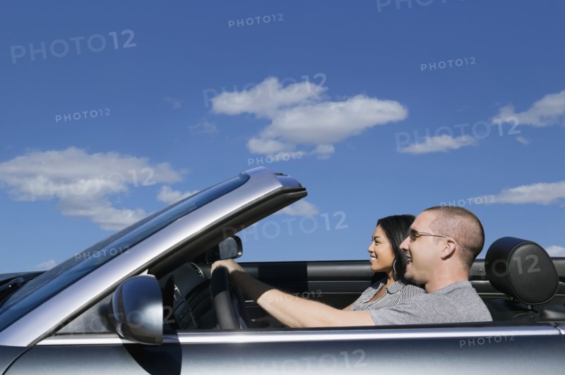 Multi-ethnic couple driving in convertible car