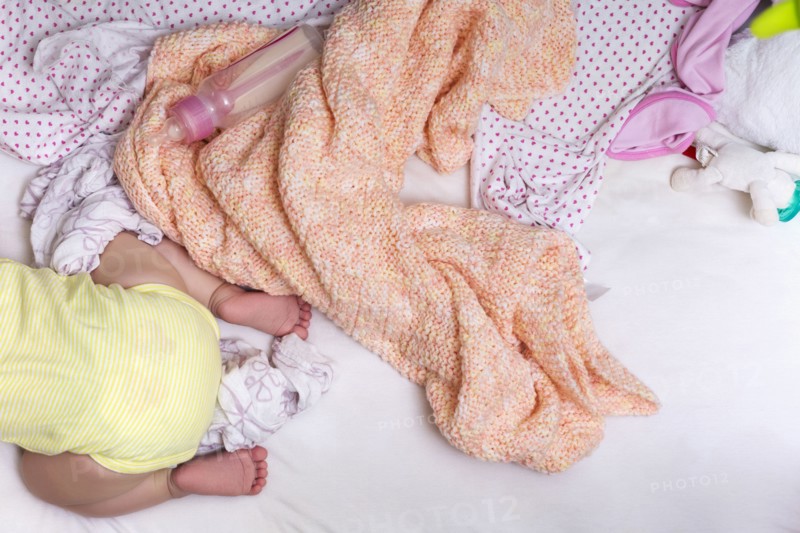 Mixed race baby girl crawling in bed
