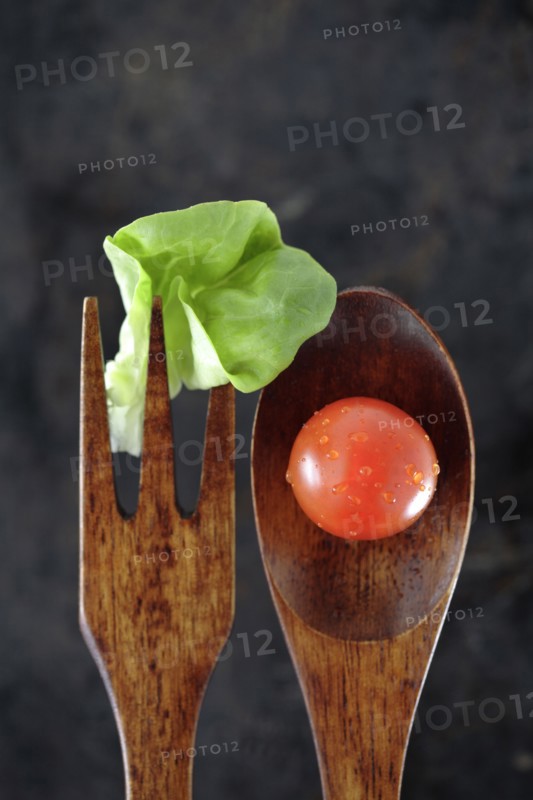 Wooden fork and spoon with lettuce and tomato