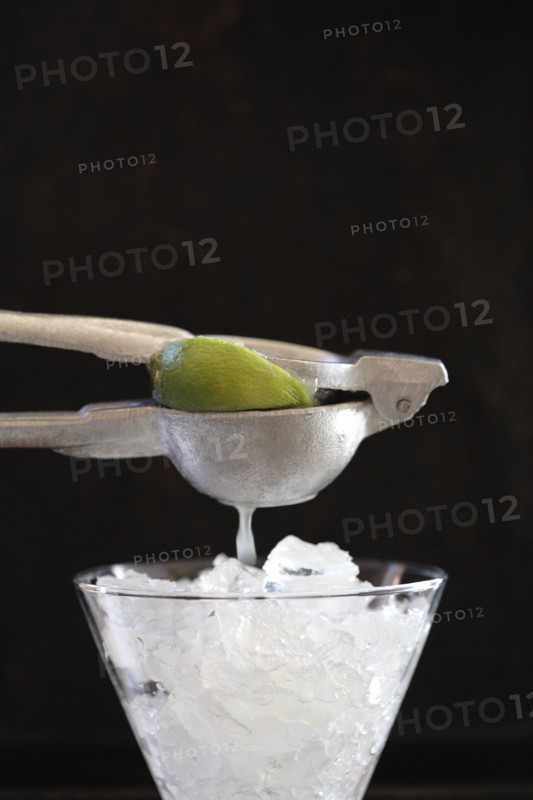 Lime being squeezed over ice