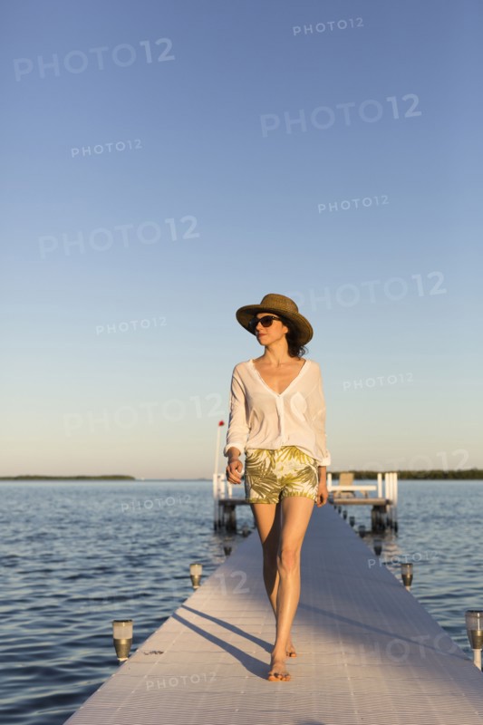 Caucasian woman walking on pier over water