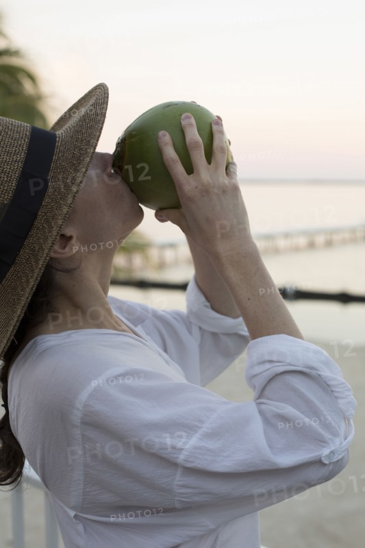Caucasian woman drinking juice from coconut