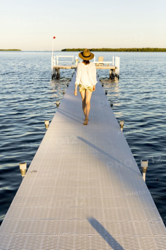 Caucasian woman walking on pier over water