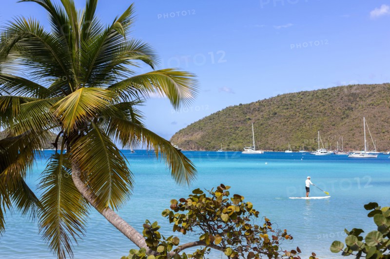 Caucasian tourist using paddle board in tropical ocean