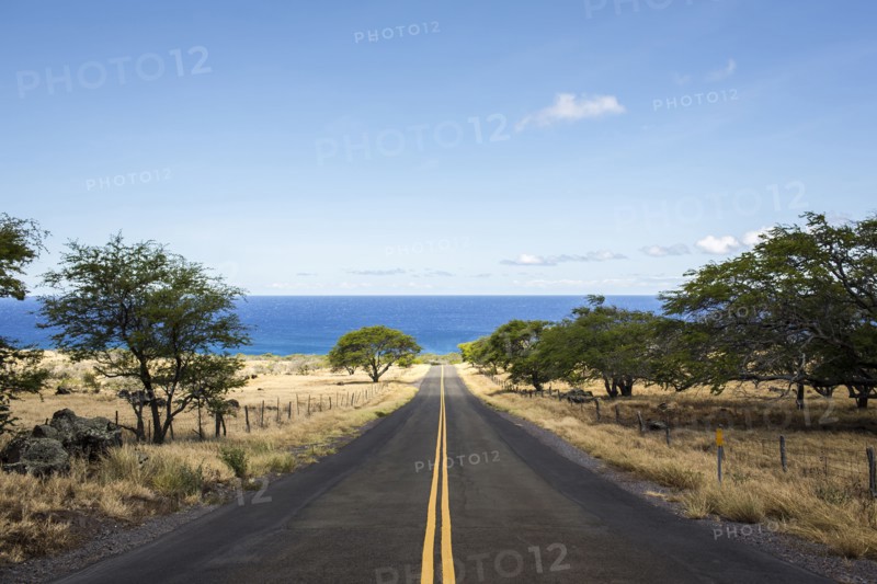 Empty road leading to ocean