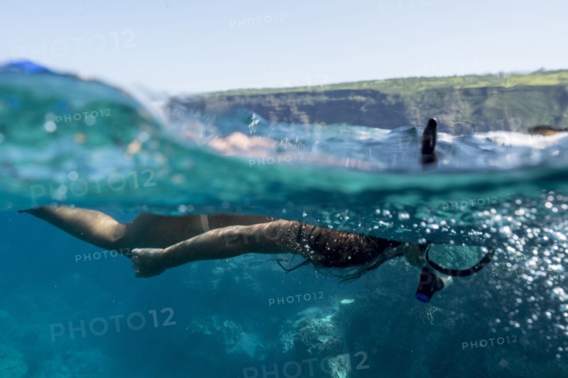 Mixed race woman snorkeling in tropical ocean