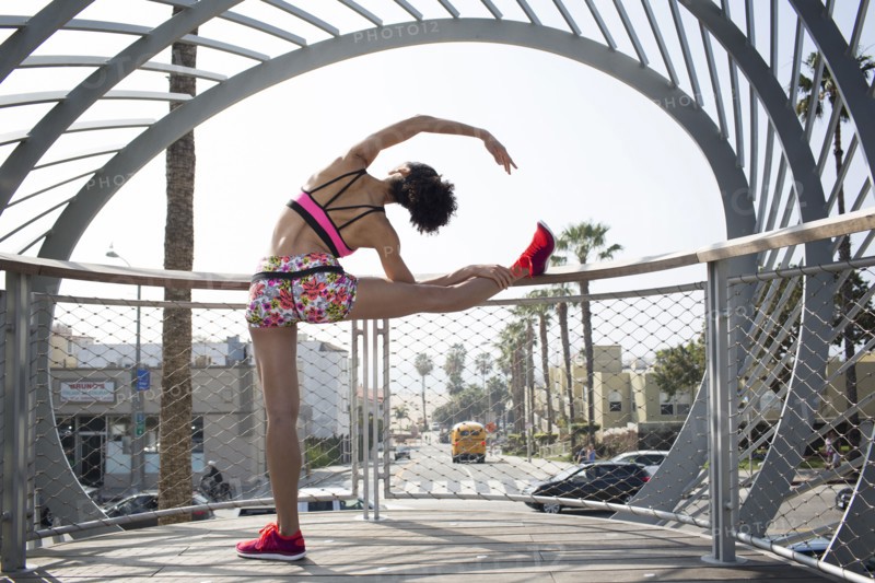 Mixed Race woman stretching leg on banister