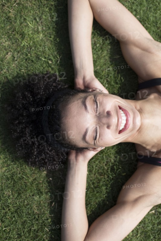 Mixed Race woman laying on grass relaxing