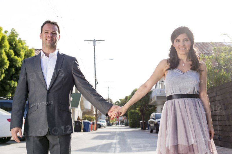 Smiling couple holding hands in alley