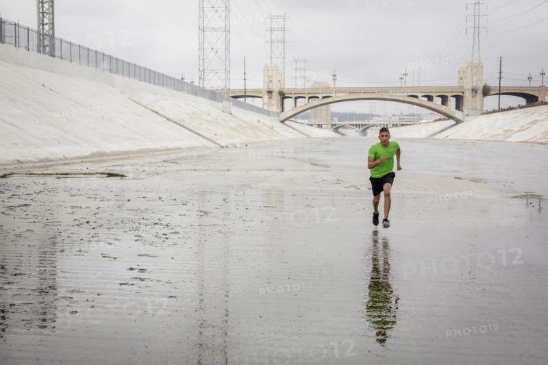 Mixed Race man running in canal
