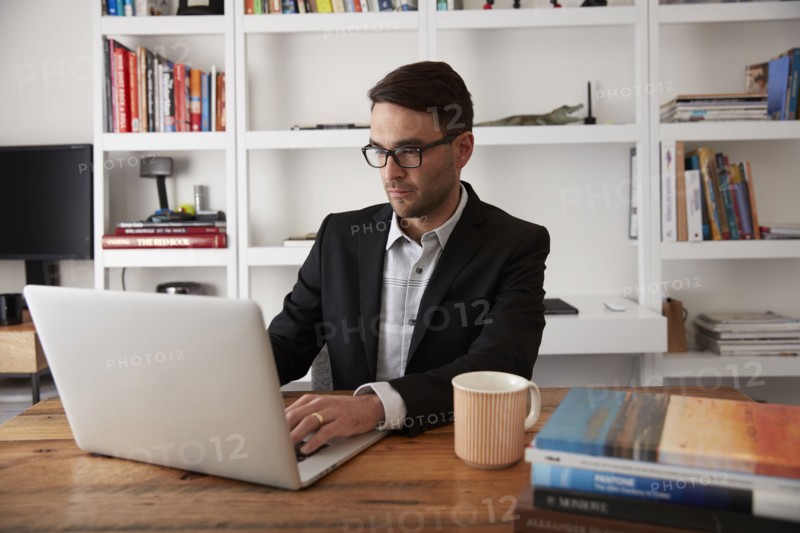 Caucasian businessman using laptop in home office