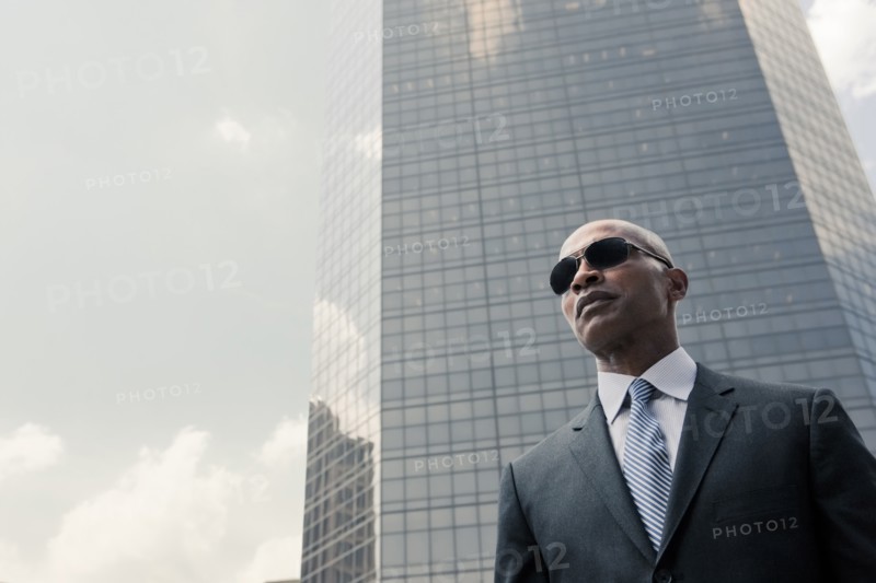 Black businessman standing near highrise