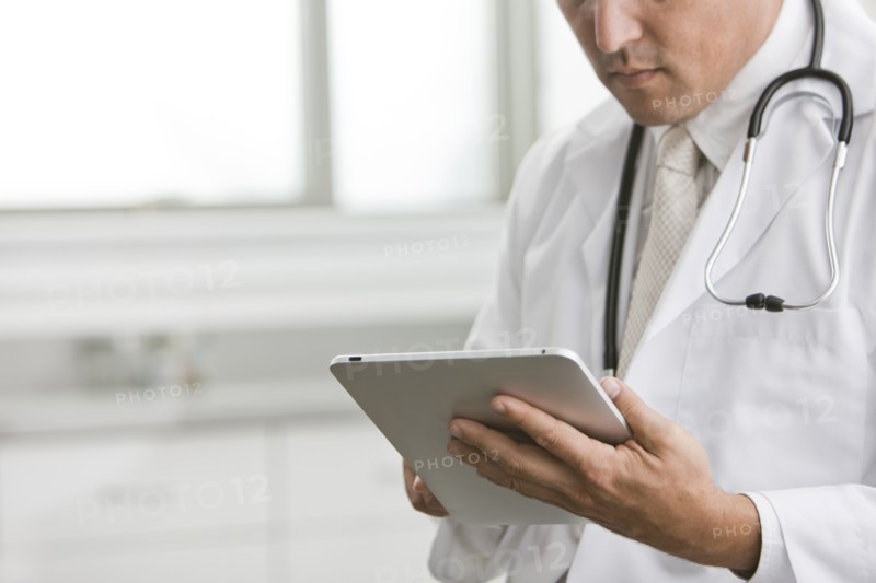 Mixed race doctor using digital tablet