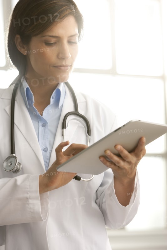 Hispanic doctor using digital tablet