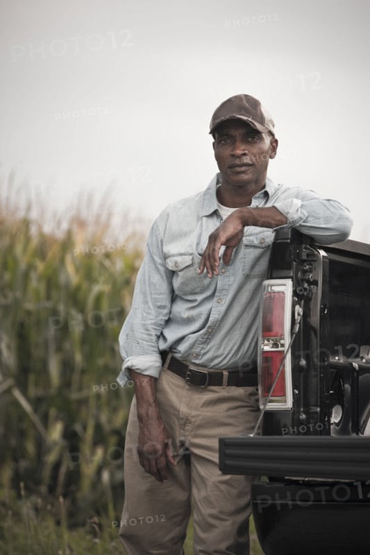 African American leaning on back of pick-up truck
