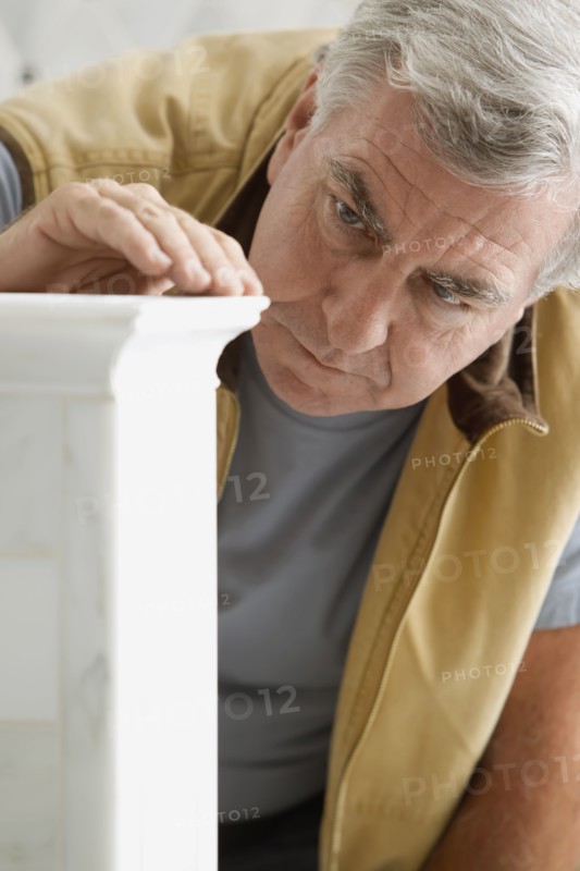 Caucasian carpenter looking at wood detail