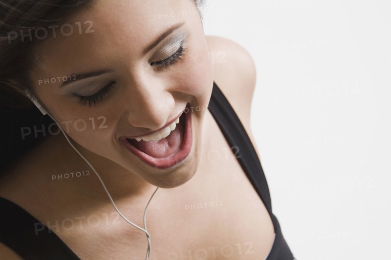 Mixed race woman listening to headphones and singing