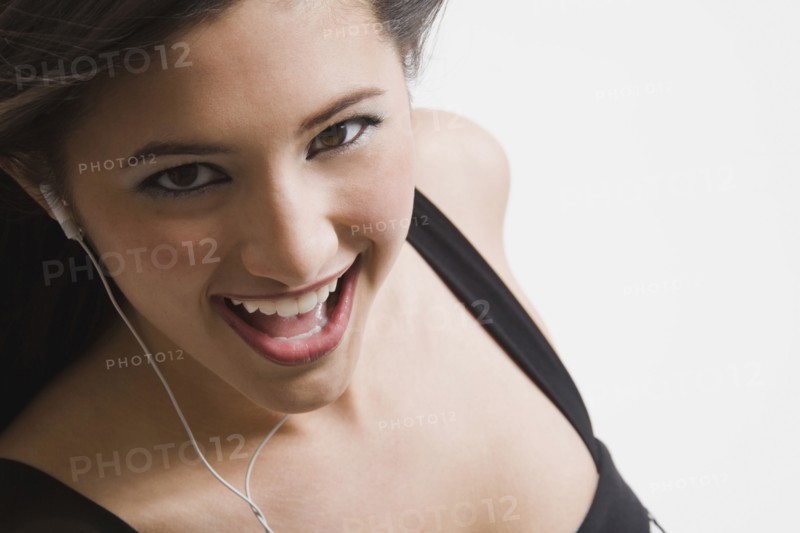 Mixed race woman listening to headphones and singing