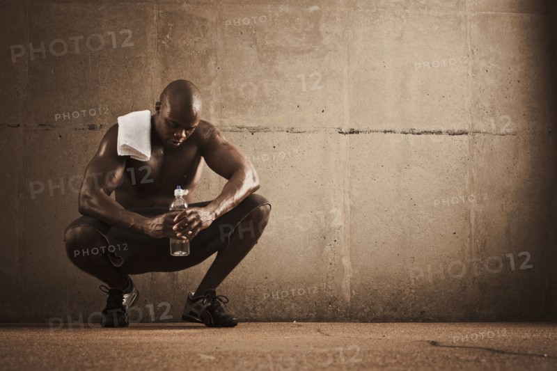 African American man drinking water after exercise