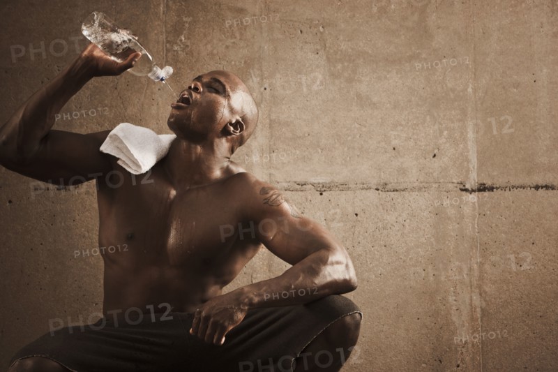 African American man drinking water after exercise