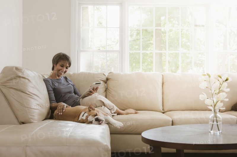 Native American woman relaxing on sofa with English bulldog