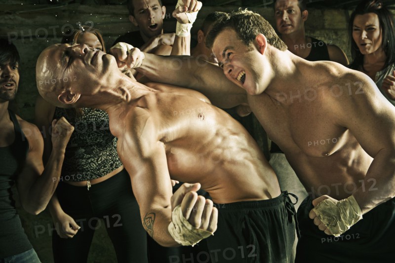 People watching boxer hitting opponent on the jaw