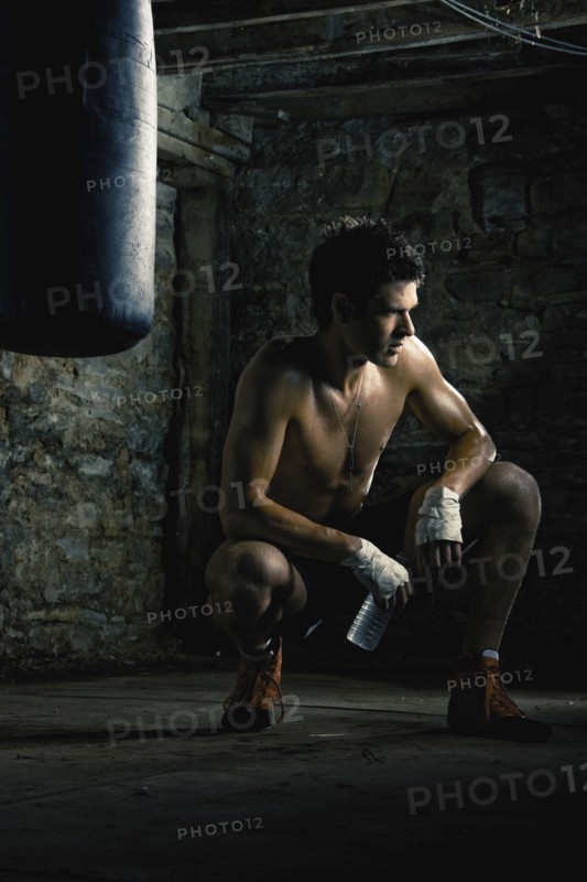 Caucasian boxer drinking water after training