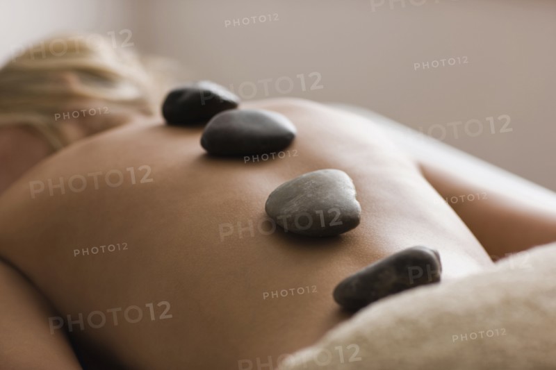 Caucasian woman receiving hot stone massage